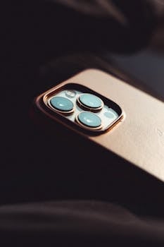 Artistic close-up of a smartphone camera lens with moody lighting, highlighting modern technology.