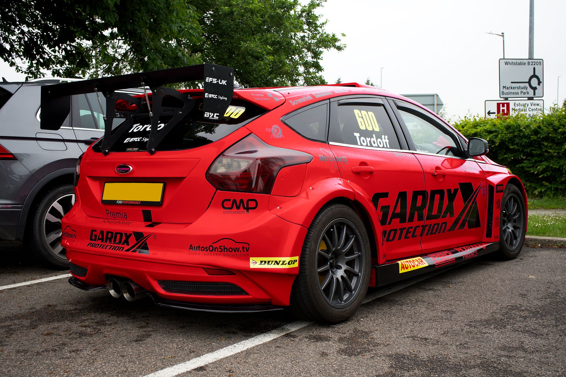 Gambar dinamis mobil balap Ford Focus RS merah yang diparkir di Whitstable, Inggris.