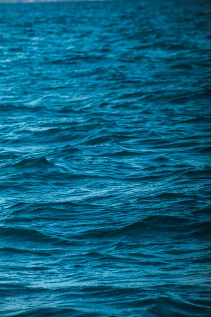 A close-up view of the ocean's dynamic and textured waves in blue hues.