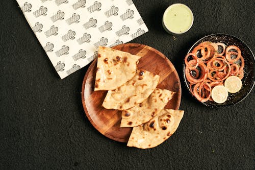 Free Slices of Flatbread on Wooden Plate Beside Onion Rings  Stock Photo