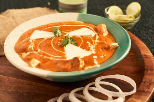 Free Delicious bowl of Indian butter chicken garnished with cream and cilantro, perfect for dinner. Stock Photo