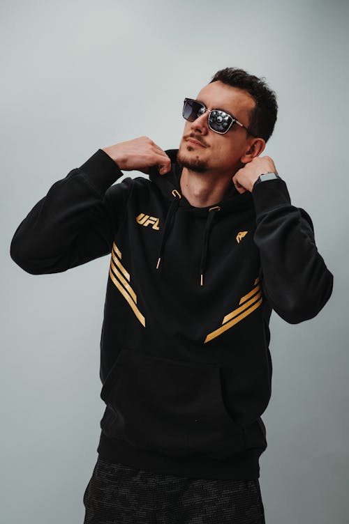 AMan in Black and Yellow Adidas Zip-Up Jacket Wearing Black Sunglasses