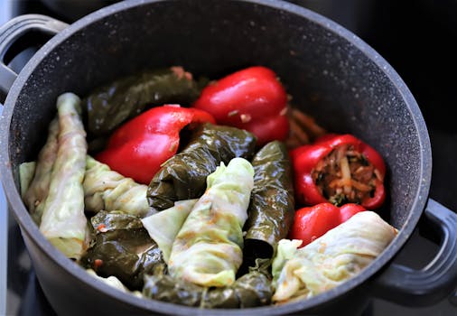 Close-up of stuffed peppers and cabbage leaves cooking in a pot. A vibrant and appetizing display.