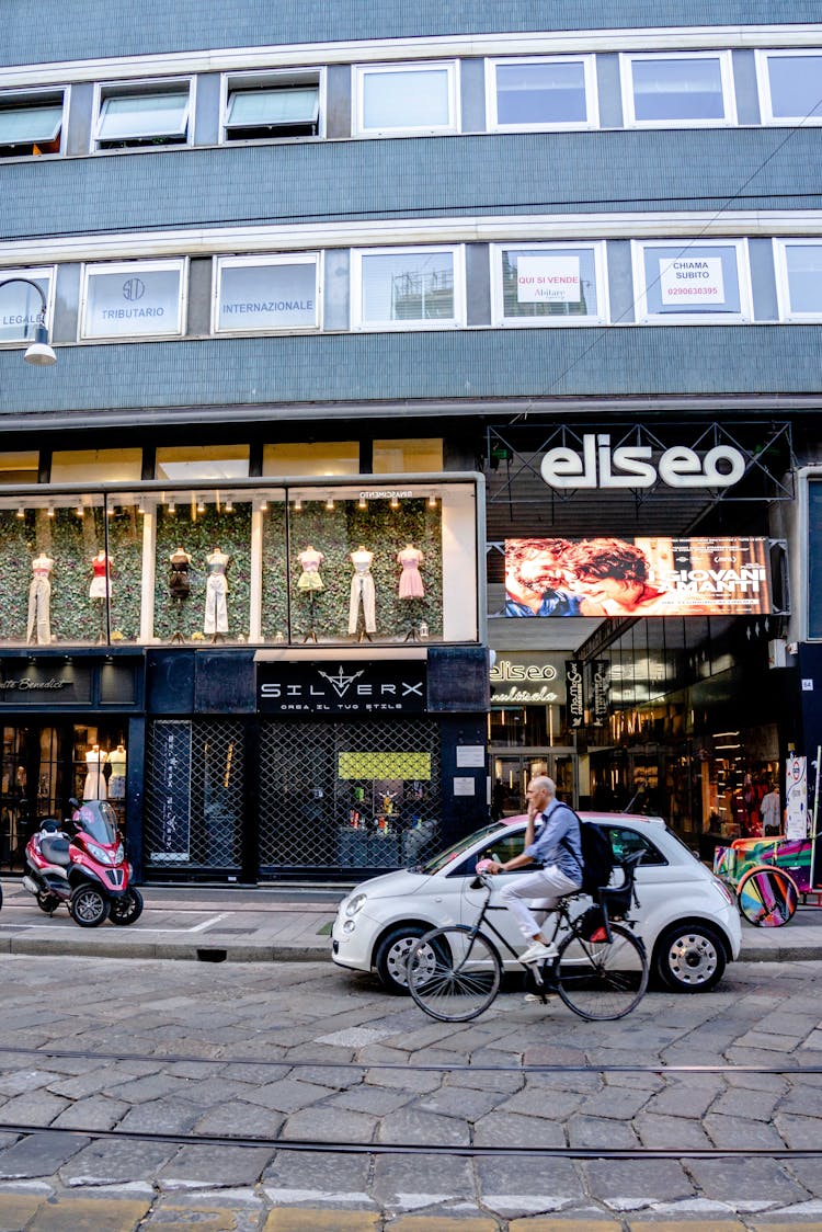 Man Riding A Bicycle Near A Commercial Building