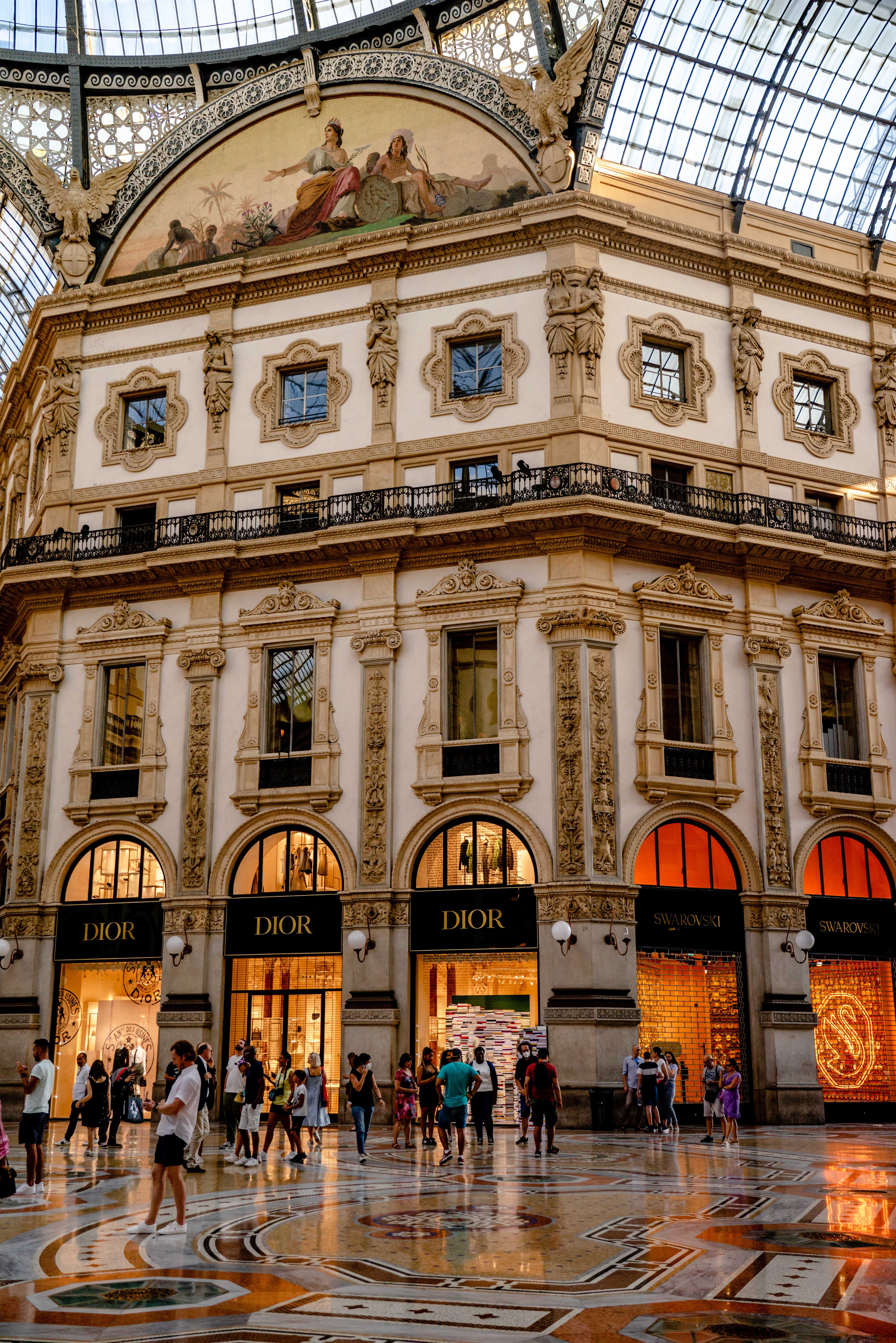 Beautiful interior view of Milan's Galleria Vittorio Emanuele II showcasing its ornamented architecture and luxury shops.