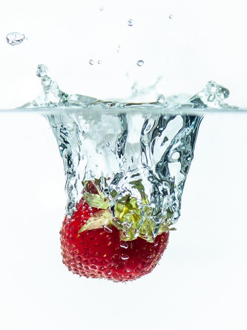 Close-up of a Strawberry Falling into Clear Water