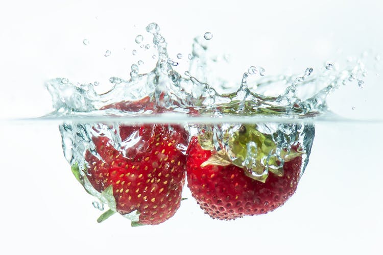 Strawberries Splashing In Water