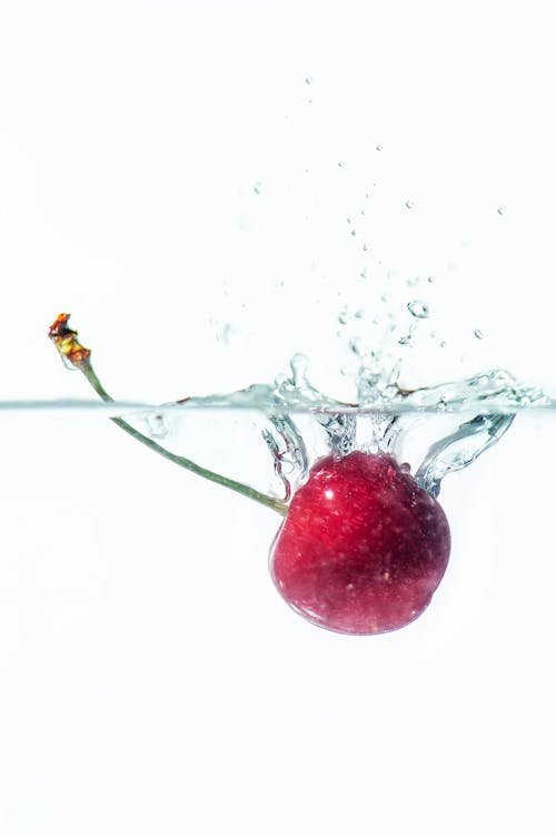 Close-up of a Cherry Falling into Clear Water