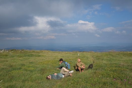 A serene moment captured with friends relaxing on a grass field under a cloudy sky in Pernik, Bulgaria.