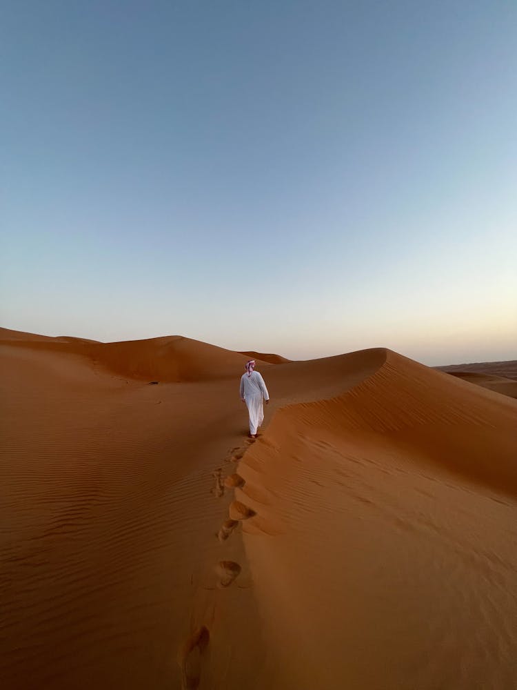 Man In Traditional Clothes Walking Desert