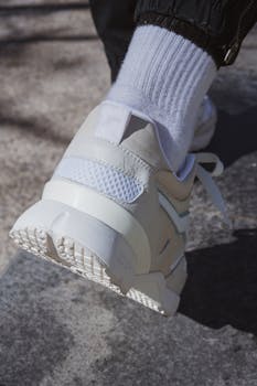 Fashionable white sneakers and socks captured outdoors in a stylish setting.