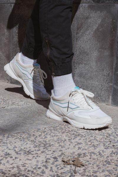 Chunky off-white running sneakers worn on a pavement — photo by Sneep Crew on Pexels