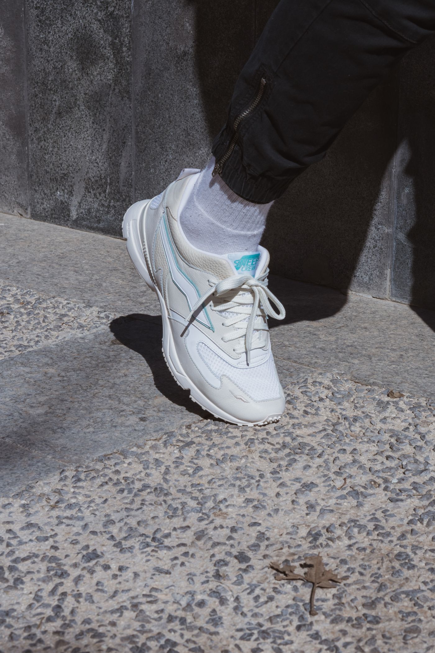 Detalle de zapatillas blancas urbanas en uso sobre pavimento