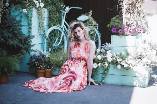 Woman Seated on the Floor Surrounded By Flowering Plants