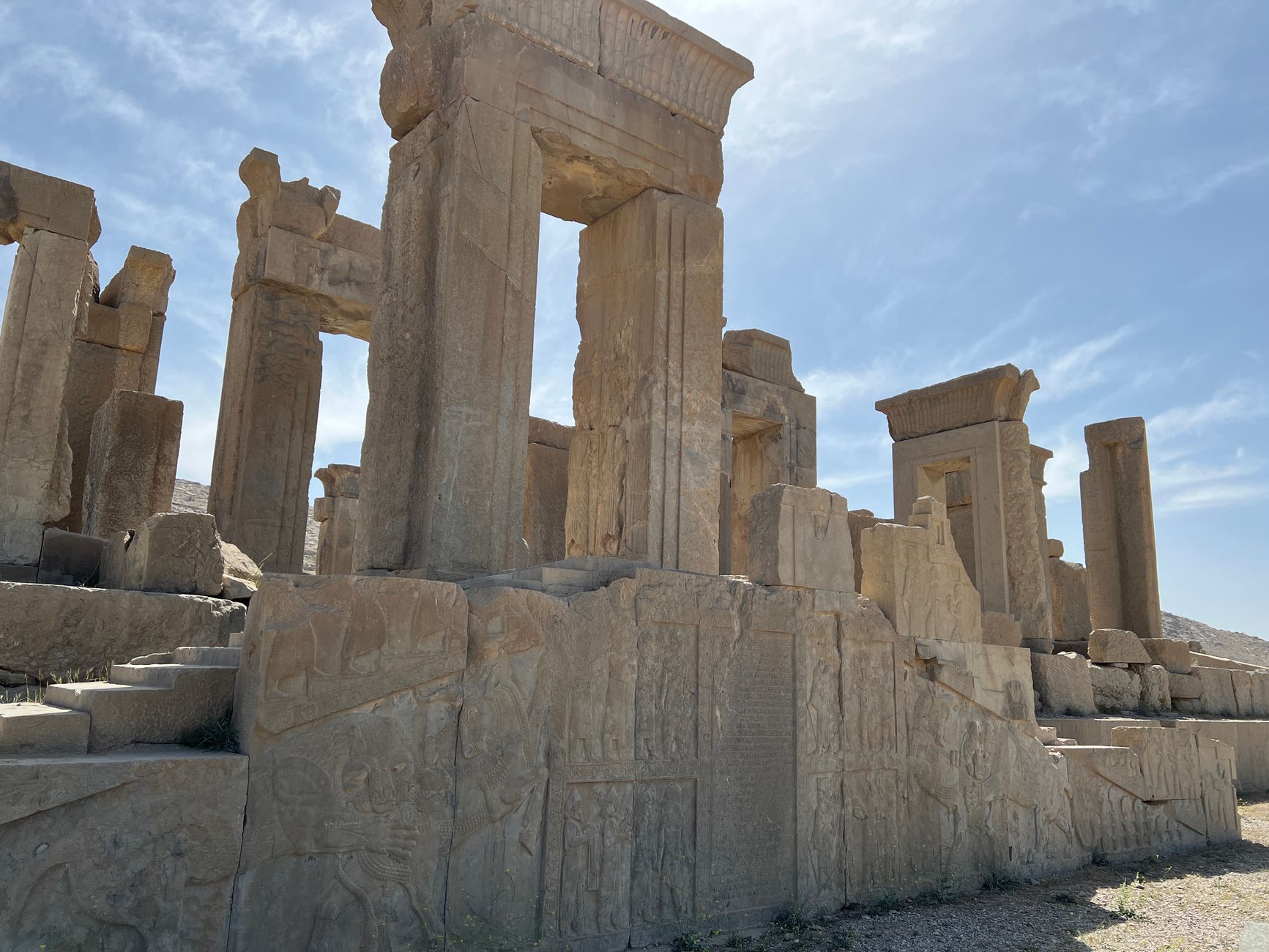Explore the majestic stone ruins of Persepolis, an ancient Achaemenid empire site in Iran, under a clear sky.