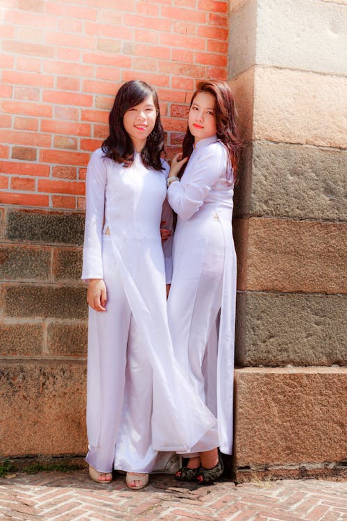 Two Young Women Posing Together in White Dresses