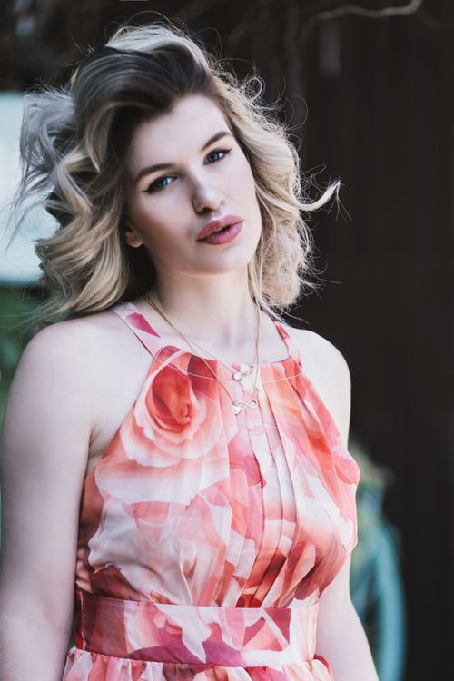 Free Stylish outdoor portrait of a woman in a floral dress with elegant makeup Stock Photo