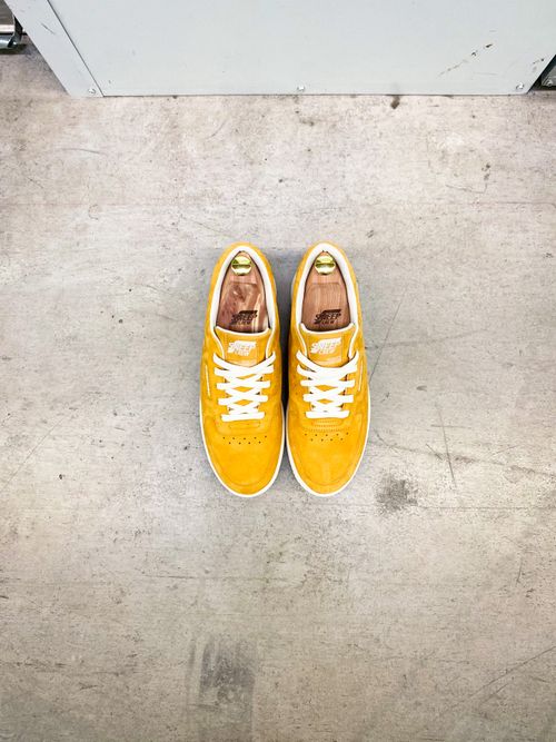 Free Top view of vibrant yellow sneakers on a neutral concrete floor. Stock Photo