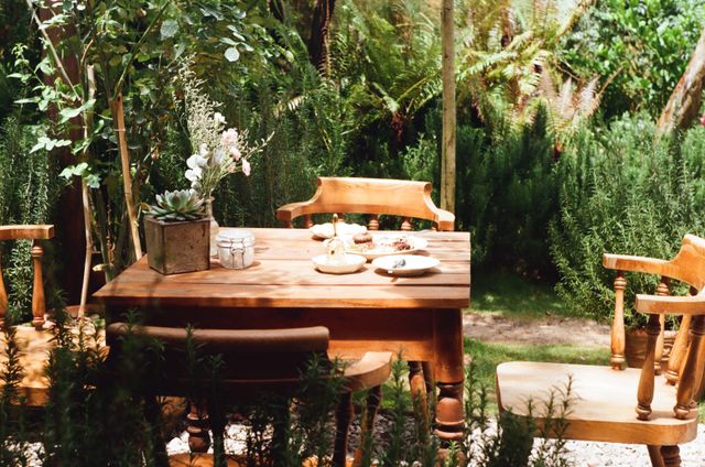 Table en bois dressée pour un salon de thé dans un jardin verdoyant près de Bordeaux