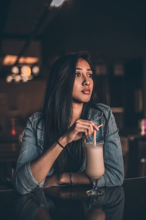Free Woman Leaning on Table Having A Drink Stock Photo
