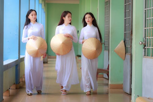 Women in White Dress Holding Conical Hats