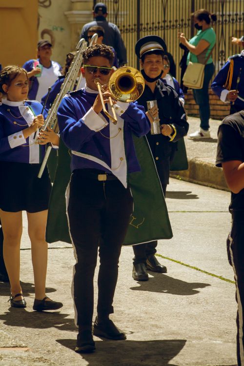 Free A colorful marching band performance on a sunny Venezuelan street, showcasing musical talent and cultural festivities. Stock Photo