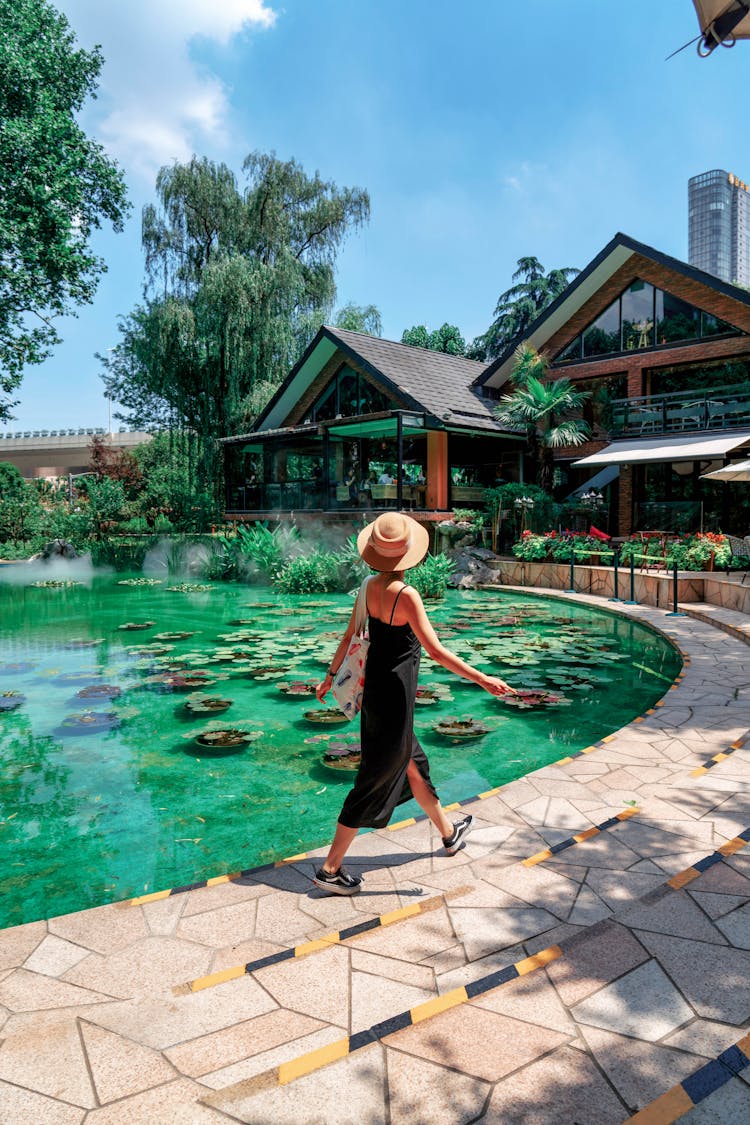 Woman Walking Along Pond