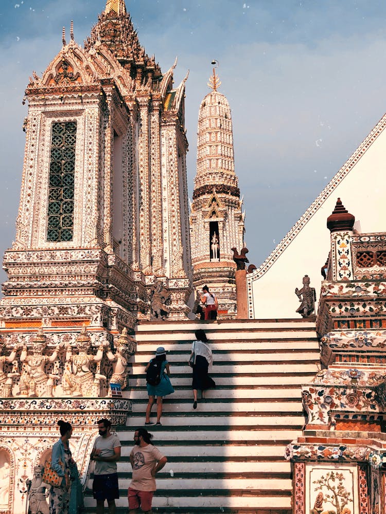 People Walking On Stairs Near White Concrete Building