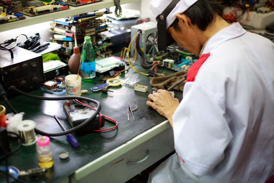 Technician working on appliance components at a bench