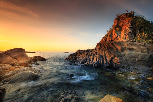 Brown Rock Formation on Sea during Sunset