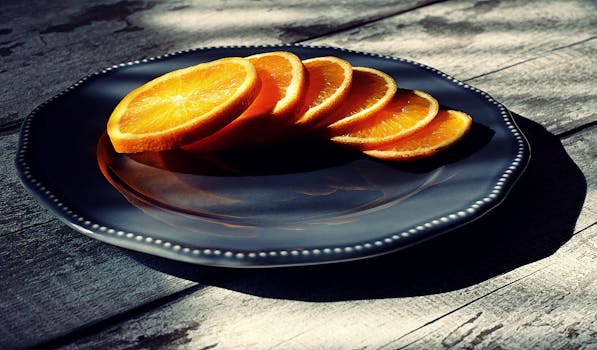 Vibrant orange slices on a dark plate, highlighting fresh, healthy eating.