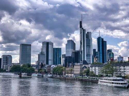 Free Stunning view of Frankfurt's skyline with modern skyscrapers by the river under dramatic clouds. Stock Photo