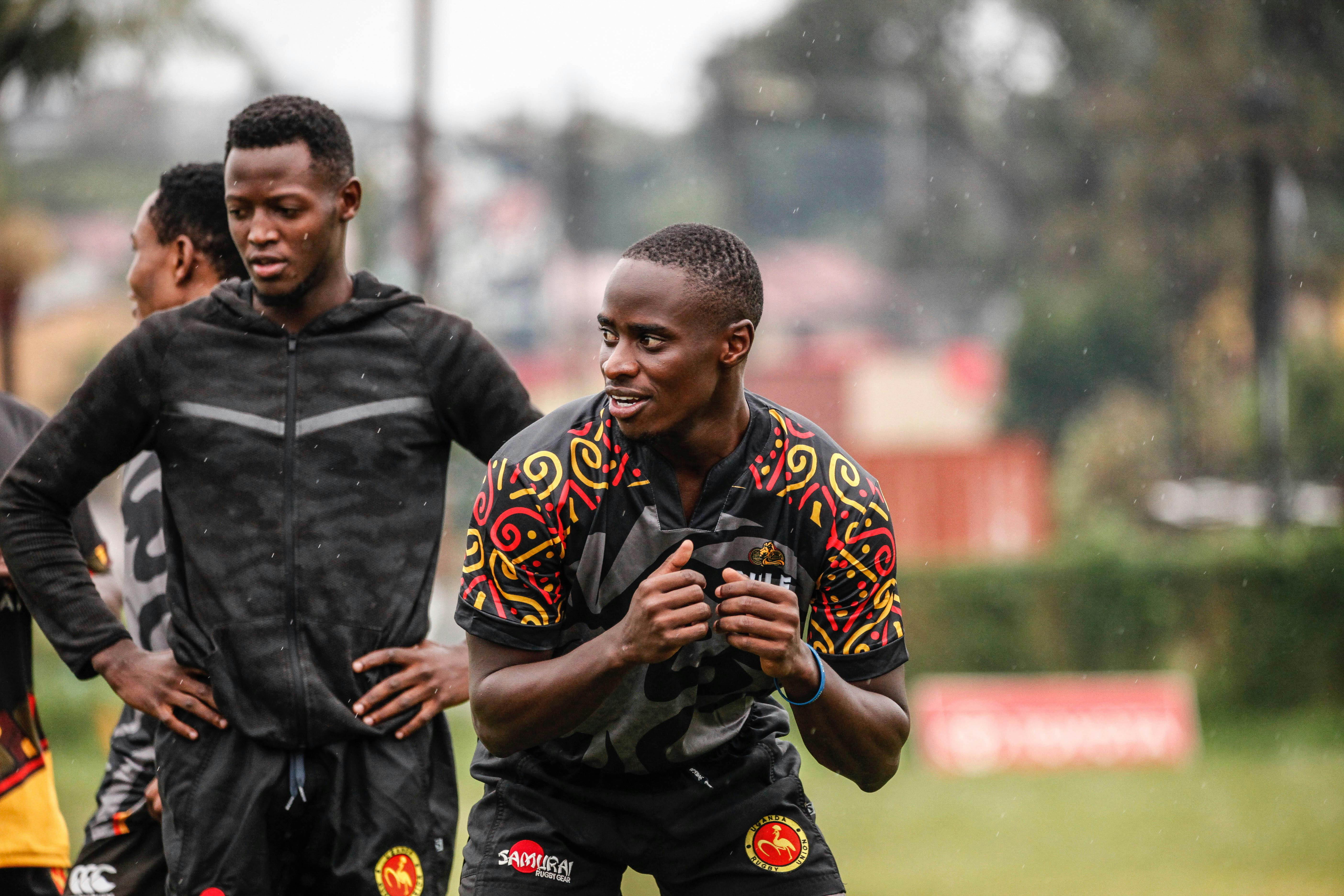 Smiling African athletes in vibrant jerseys have a team practice outdoors.