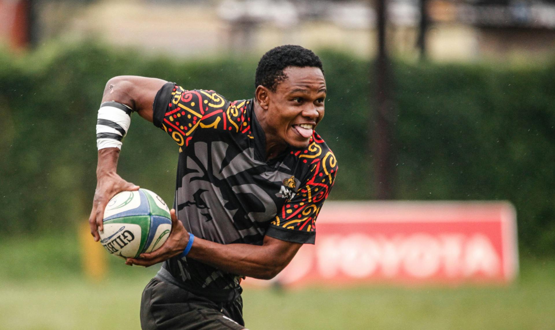 Adrian Kasito Wearing Black Uniform Running while Holding Rugby Ball