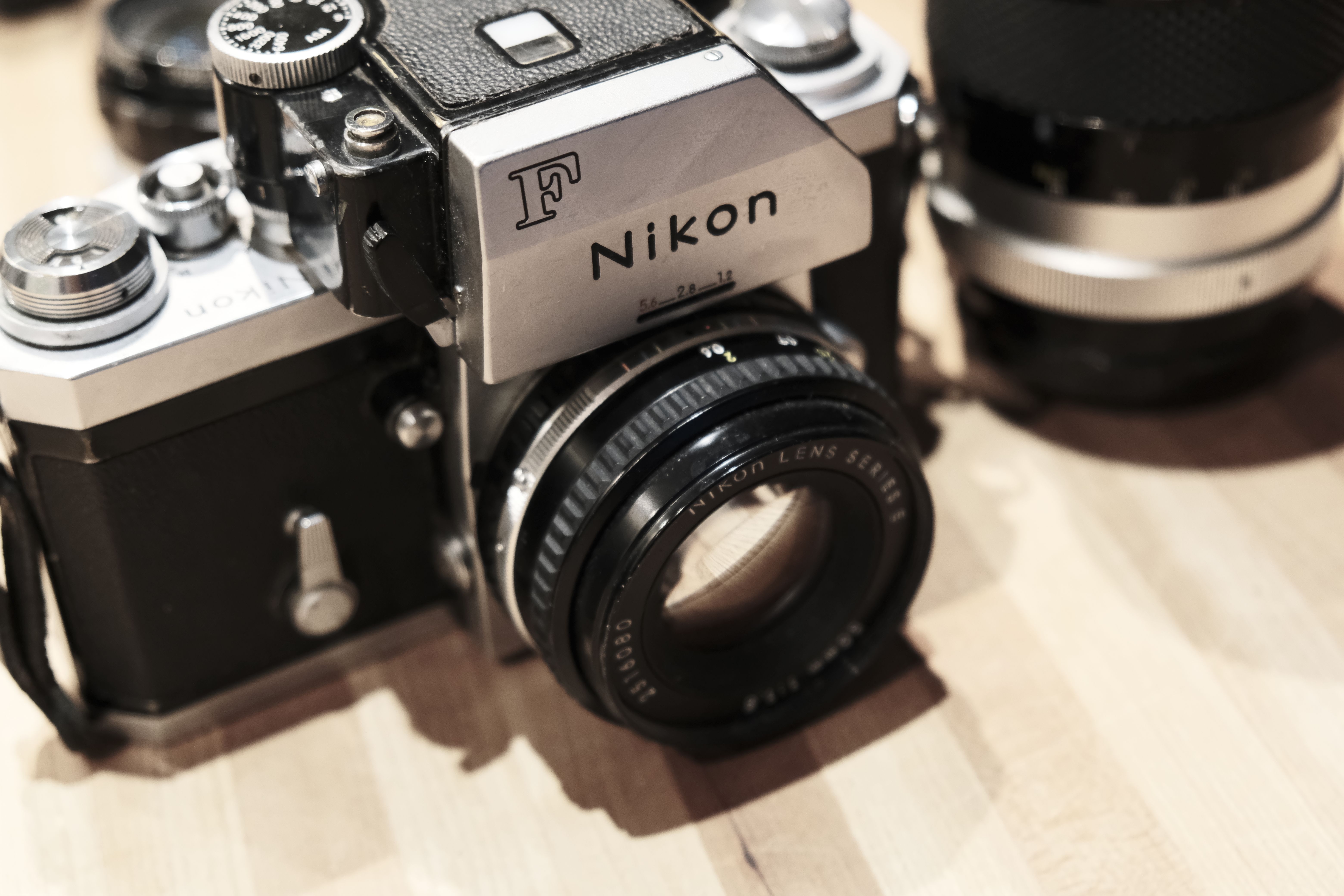 Close-up of a retro vintage Nikon camera resting on a wooden surface.