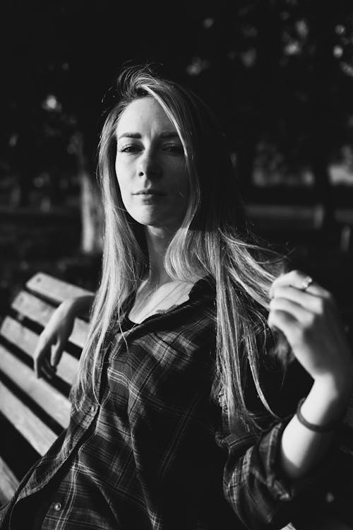 Grayscale Photo of a Woman in Plaid Long Sleeves