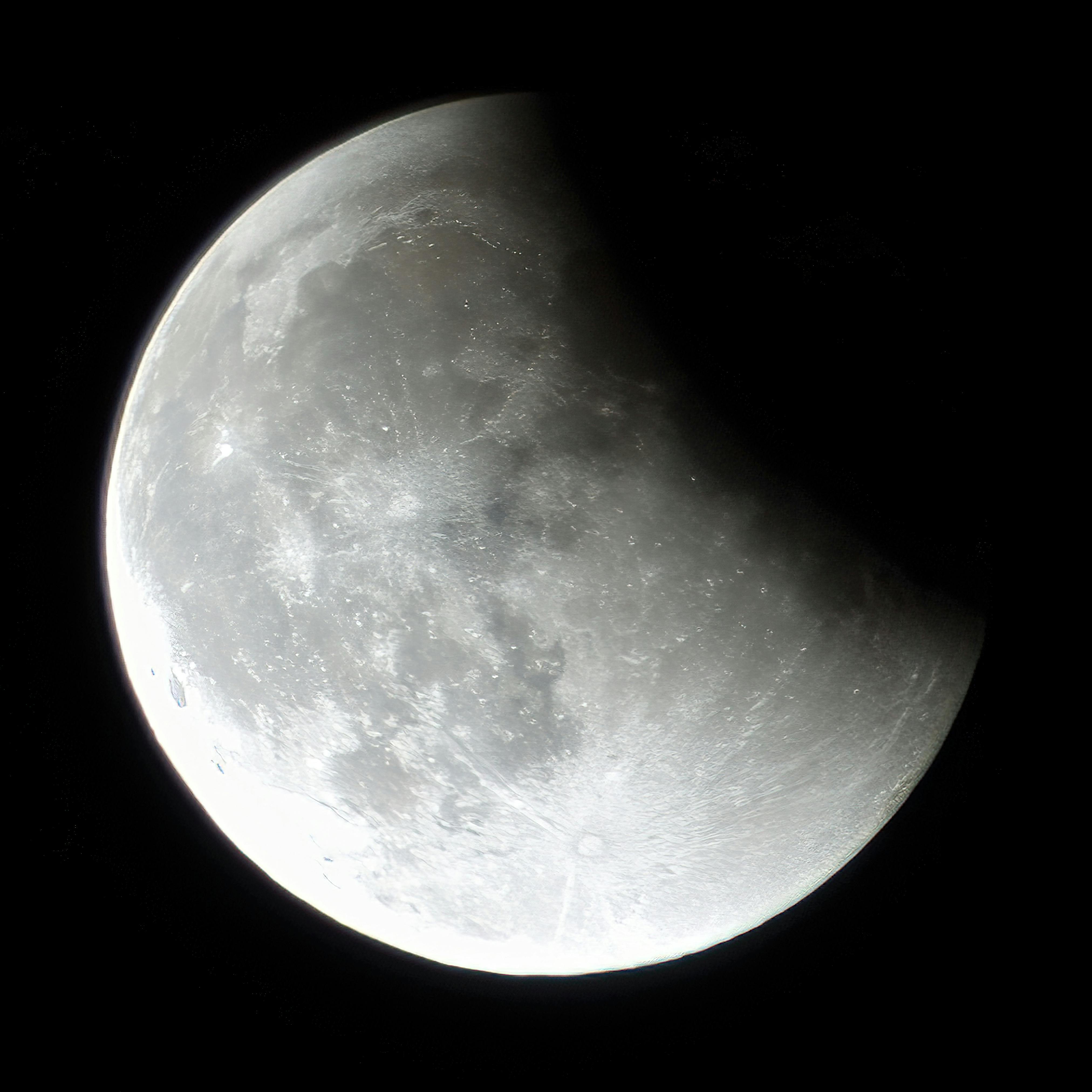 Detailed monochrome close-up of the moon's surface at night.