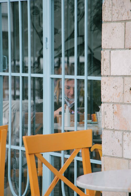 Woman Sitting behind Restaurant Windows