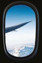 透过飞机舷窗，壮丽的雪山景色尽收眼底，展现了航空旅行的独特魅力