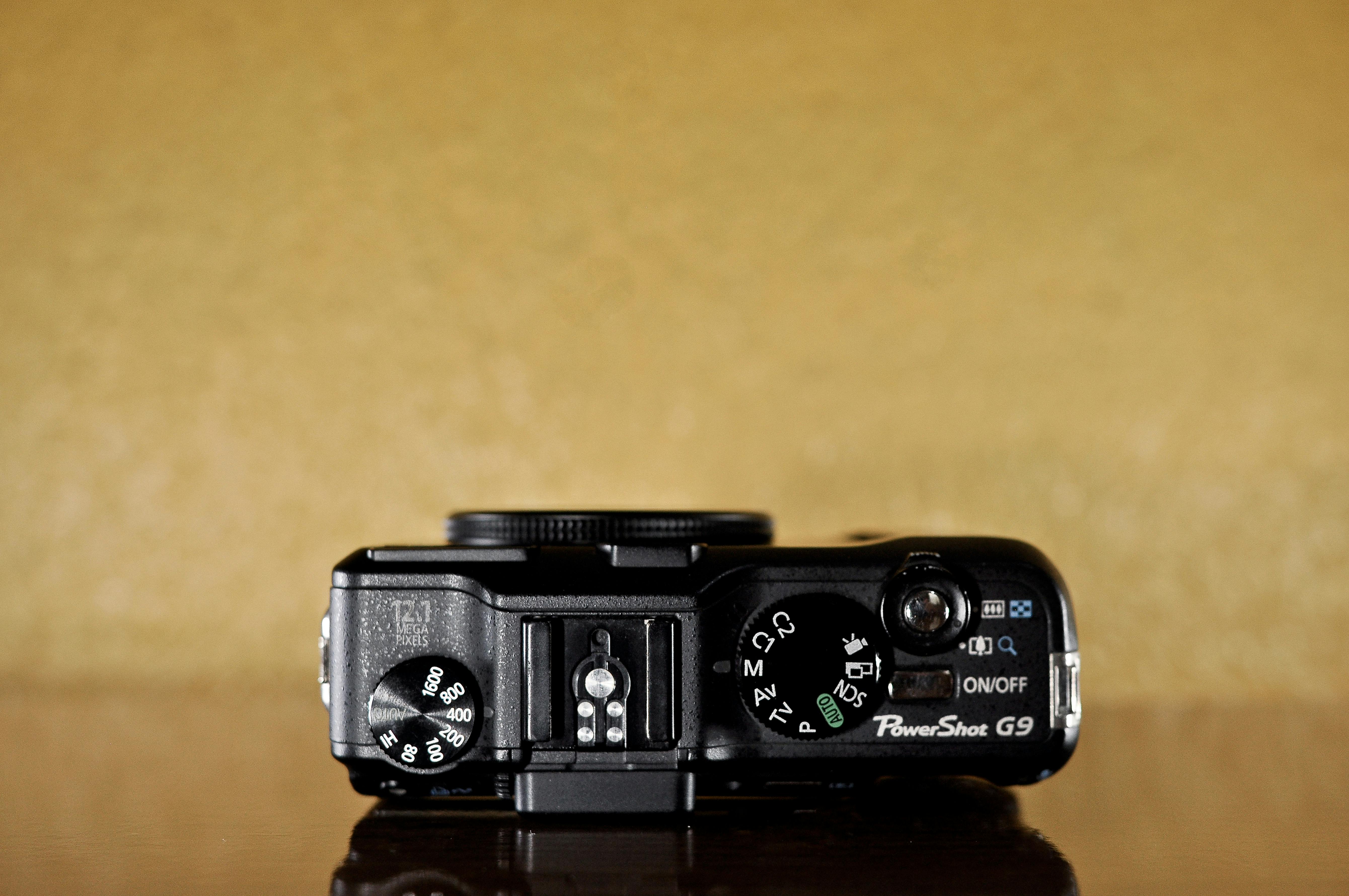 Free Top view of a digital camera showcasing dials and controls on a beige background. Stock Photo
