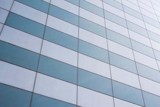 现代玻璃立面的特写，展示了几何图案，位于摩天大楼上