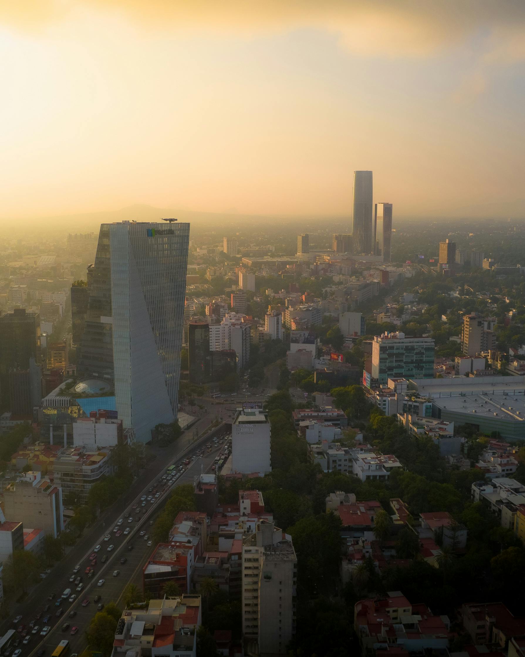 A breathtaking aerial view of Mexico City's skyline at sunset featuring modern skyscrapers and urban landscape.