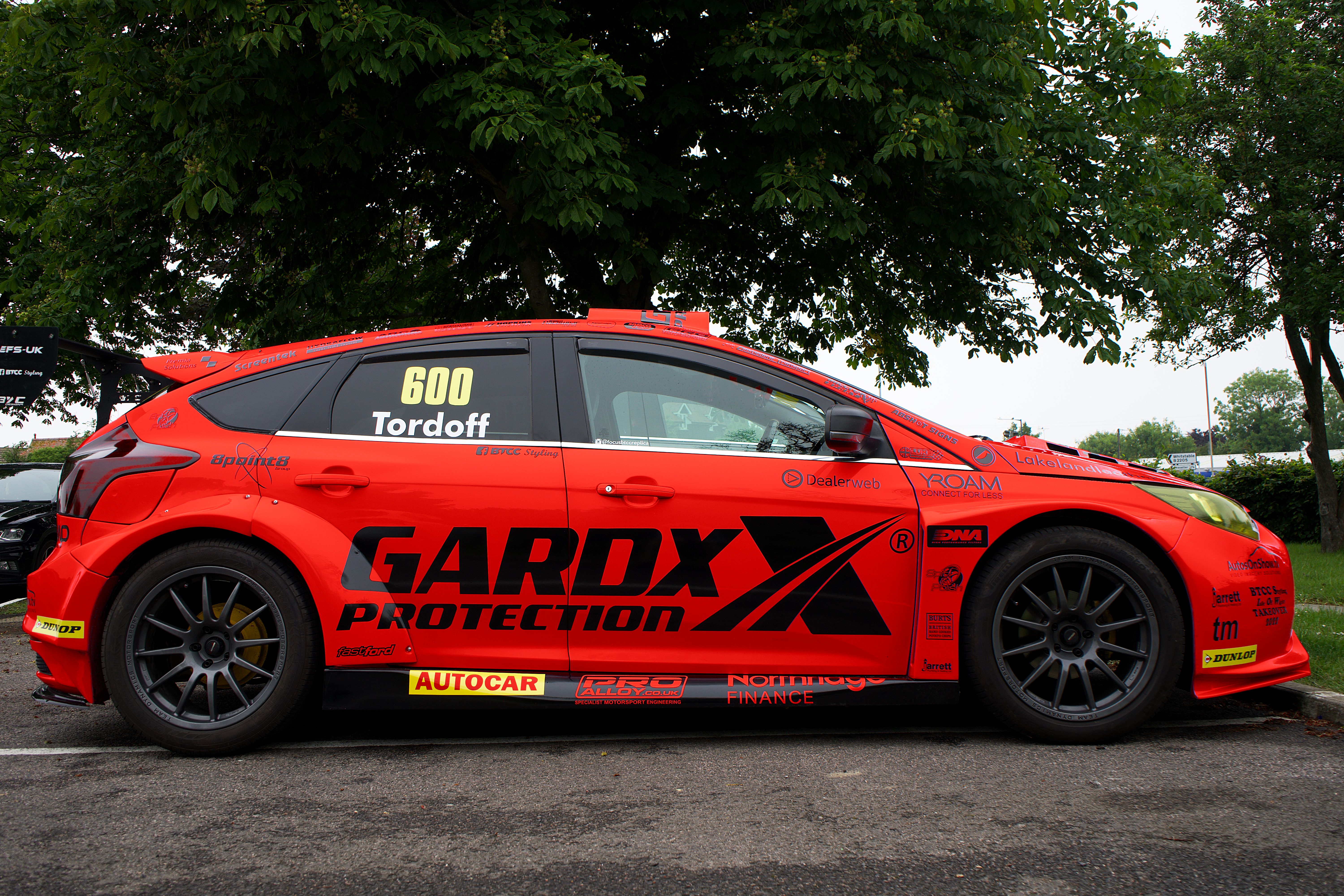 Side view of a red sports car with racing stickers in Whitstable, England.