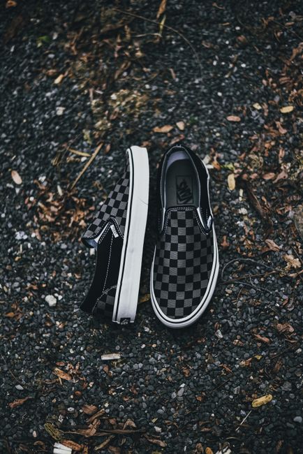 Fotomural Primer plano de zapatillas slip-on a cuadros sobre grava, perfectas para la moda casual.