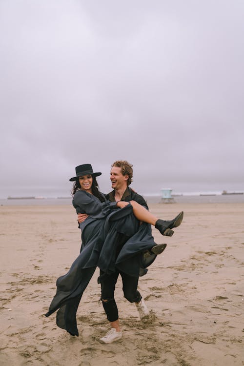 Man Carrying His Girlfriend and Running on a Beach 