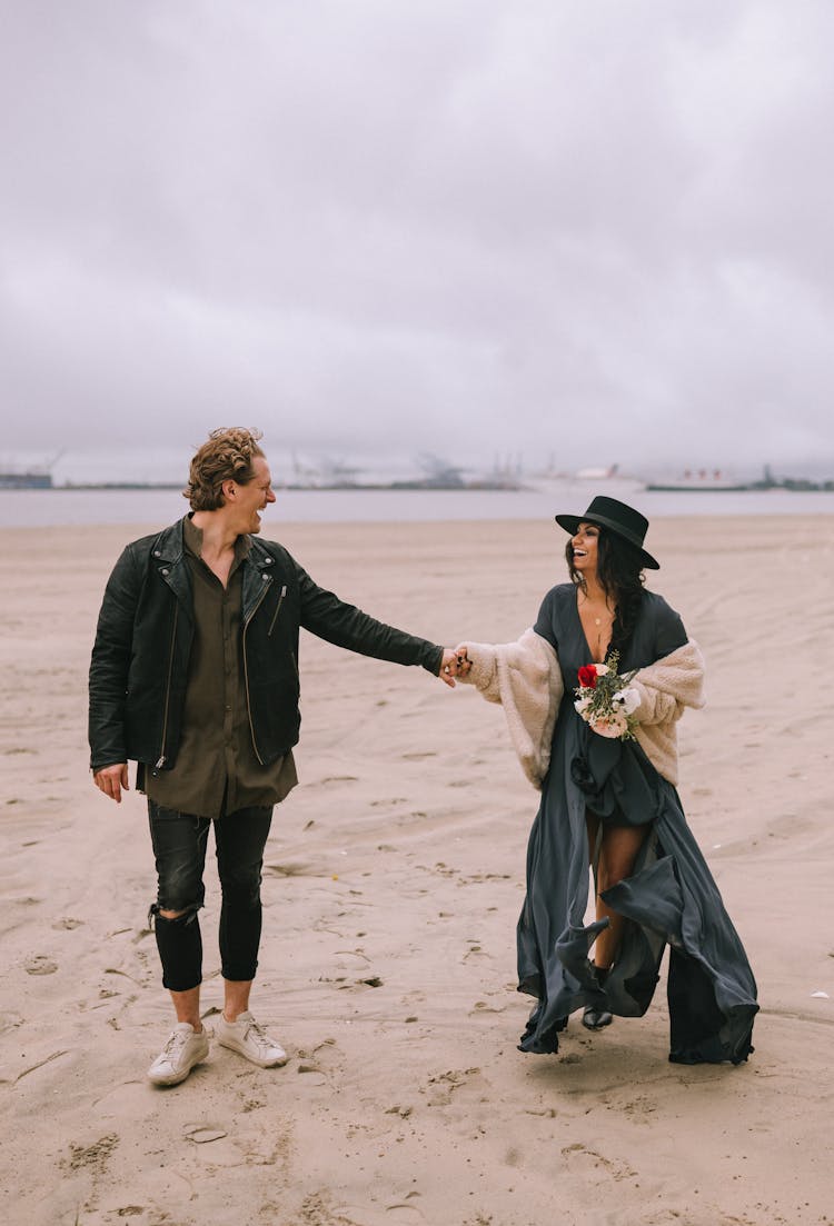 A Couple Doing Holding Hands At The Beach