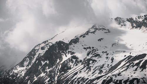 Snow Covered Mountain Under Cloudy Sky