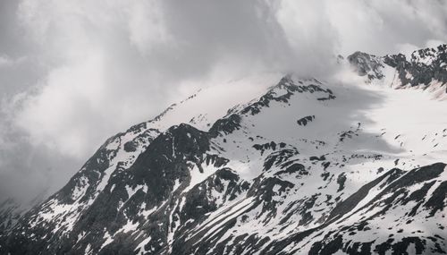 Free Breathtaking view of snow-covered mountains under a dramatic cloudy sky in Tirol, Austria. Stock Photo