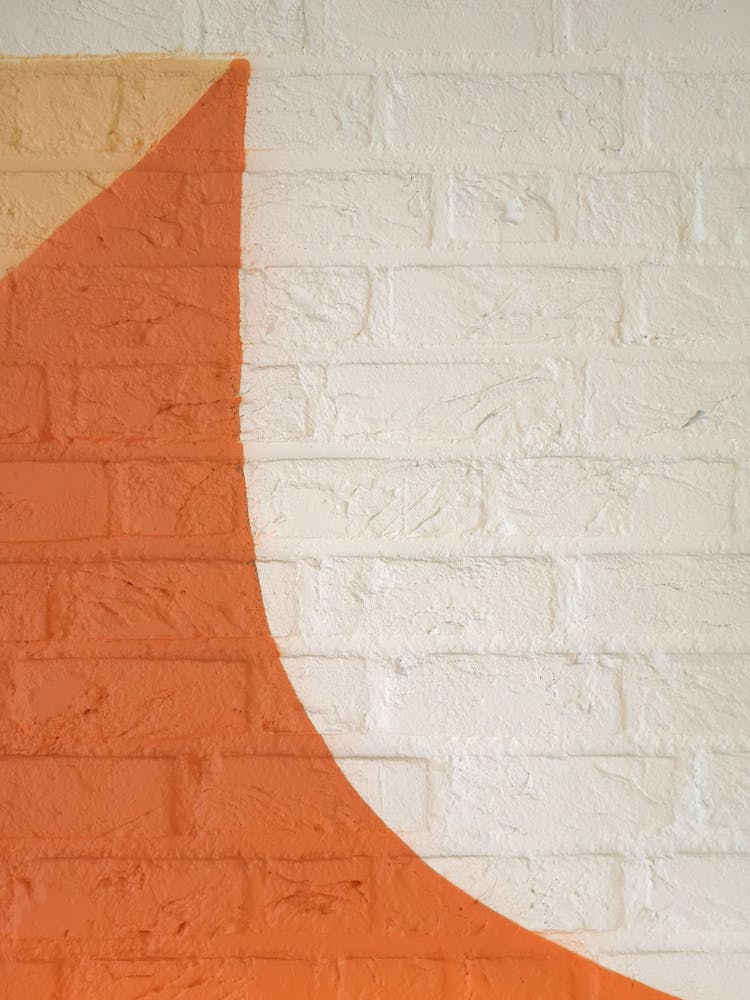 View Of A Brick Wall Painted With White And Orange Paint