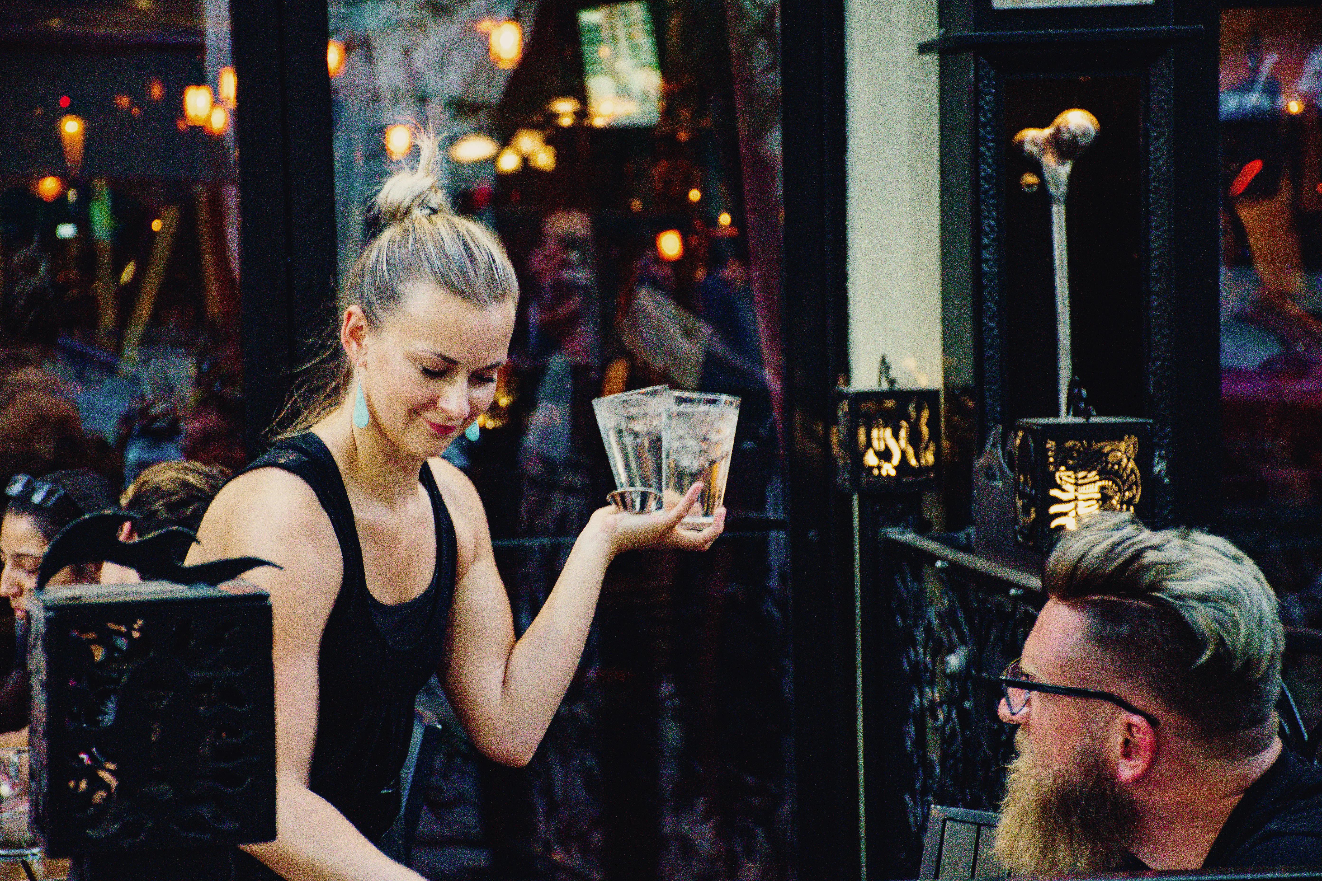 Woman Holding Higball Glass in Front of Man